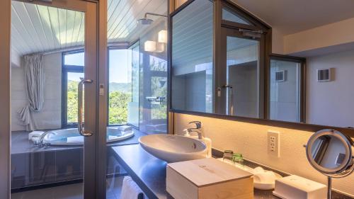 a bathroom with a sink and a large mirror at Riverte Kyoto Kamogawa in Kyoto