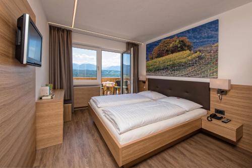 a hotel room with a bed and a television at Pension Irma in Caldaro