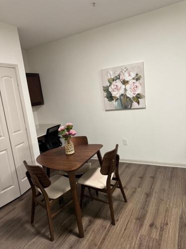 a dining room table with two chairs and a vase of flowers at Frisco Getaway in Frisco