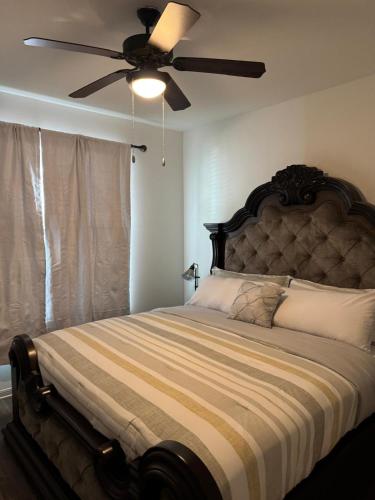 a bedroom with a large bed with a ceiling fan at Frisco Getaway in Frisco