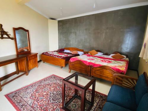 a bedroom with two beds and a mirror at Srilak View Holiday Inn in Haputale