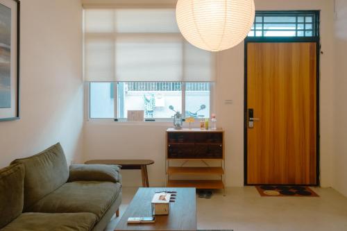 a living room with a couch and a door at Bou house in Tainan