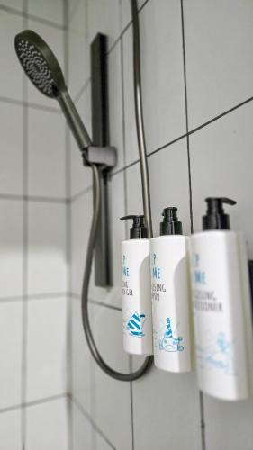 a group of three bottles of soap in a shower at Alpin Motel & Conference Centre in Rotorua