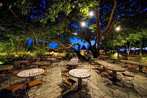 a group of tables and chairs in a park at night at Nepheli Hotel in Kastrosikia
