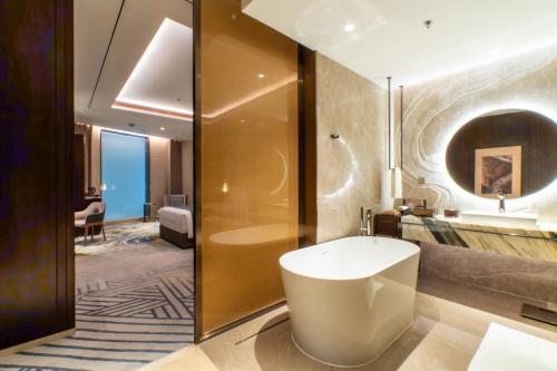 a bathroom with a bath tub and a sink at Arjuna Resort & Spa in Sihanoukville