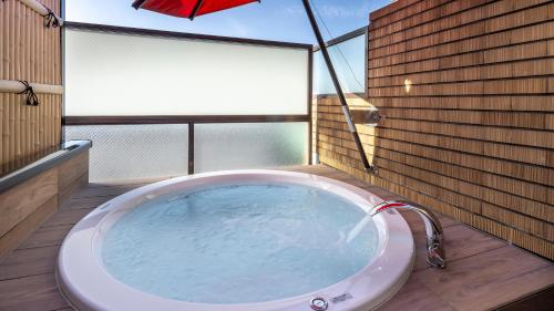 a large bath tub in a room with windows at Riverte Kyoto Kamogawa in Kyoto