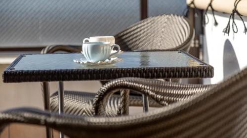a coffee cup sitting on a table with chairs at Riverte Kyoto Kamogawa in Kyoto
