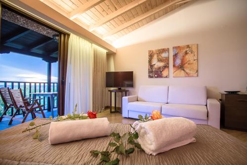 a living room with a couch and a living room with a balcony at Nepheli Hotel in Kastrosikia