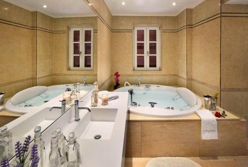a large bathroom with two tubs and two sinks at Aristotelio Boutique Hotel in Pedoulas