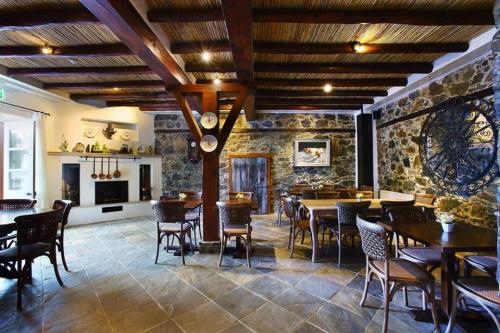 a restaurant with tables and chairs and a stone wall at Aristotelio Boutique Hotel in Pedoulas