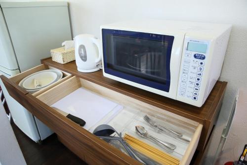 a microwave oven sitting on top of a cabinet at Nao house in Takaishi