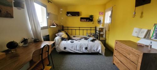 - une chambre avec un lit dans une pièce jaune dans l'établissement DUPLEX INTRA-MUROS calme & spacieux près du Palais des Papes, à Avignon