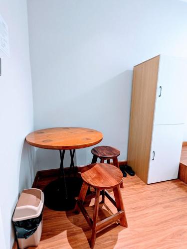 a table and two stools in a room at Tonle Hostel in Phnom Penh
