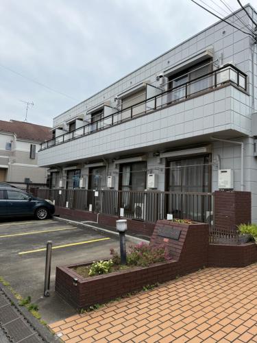 a building with a parking lot in front of it at 17 minutes from Shinjuku, room 108 in Tokyo