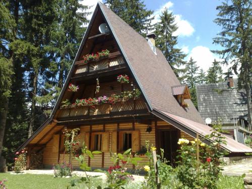 a house with a gambrel roof with flowers on it at Holiday Home Tirol in Vlasic