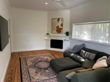 a living room with a couch and a rug at Pristine and Private on Pemberton in Albury
