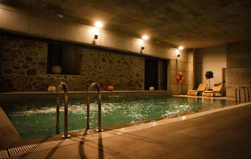 a swimming pool with lights in a building at Parador de La Granja in La Granja de San Ildefonso