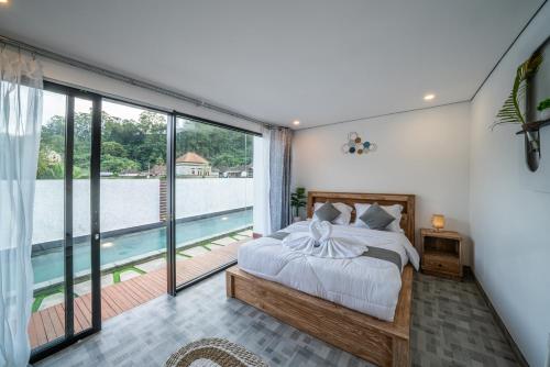 a bedroom with a bed and a view of a pool at Heaven House Kintamani in Kubupenlokan