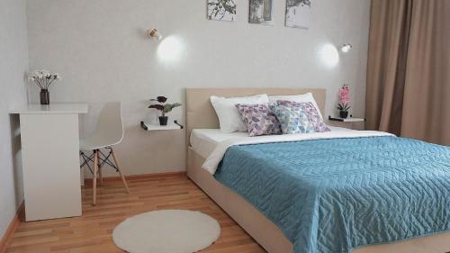 a small bedroom with a bed and a white table at 2комн апартаменты на Океане у Галины in Semey