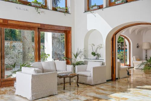 a living room filled with furniture and a large window at Hotel Syrene in Capri