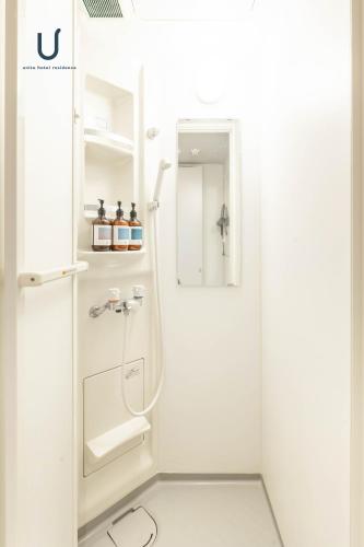 a white bathroom with a shower and a sink at Hotel Residence Asakusa by unito in Tokyo