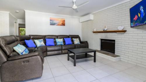a living room with a couch and a fireplace at Shelly's Beach House in Bellara