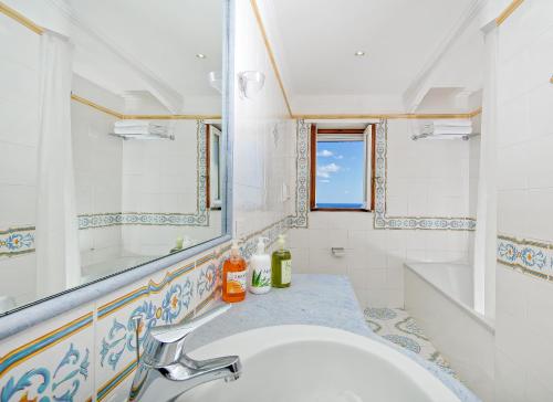 a bathroom with a sink and a mirror at Hotel Syrene in Capri