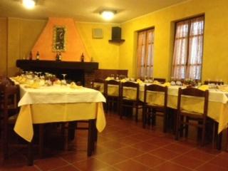 a dining room with tables and chairs with yellow walls at Locanda Del Sole in Mozzanica