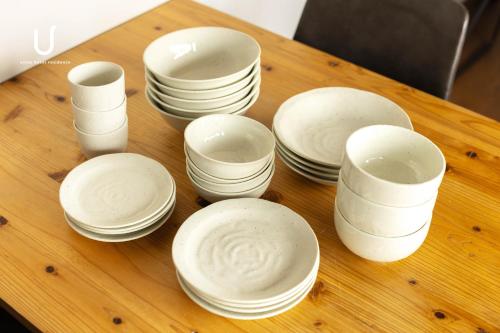 a group of white dishes sitting on a wooden table at Hotel Residence Asakusa by unito in Tokyo