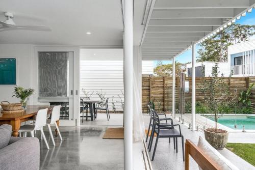 a living room and dining room with a table and chairs at Sanctuary Spaces - Lomani Six in Byron Bay