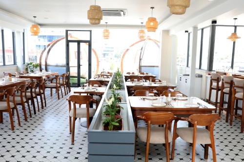 a restaurant with wooden tables and chairs and windows at Hotel Marcopolo in Kathmandu