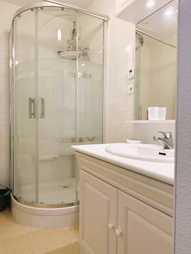 une salle de bain avec une douche en verre et un lavabo dans l'établissement Le Clos D'illies, à Mers-les-Bains