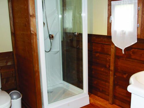 une douche avec une porte vitrée dans une salle de bain dans l'établissement Camping des Papillons, à Lalizolle