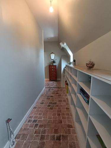 an attic hallway with a brick floor and a staircase at Le Prieuré des Anges in Saint-Quentin-les-Anges