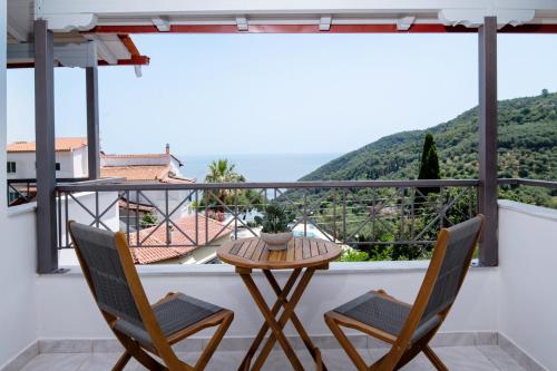 a balcony with a table and chairs and a view at The Well Lichnos in Parga