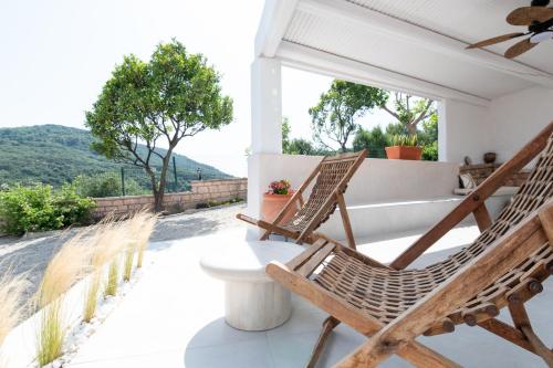 a pair of chairs on the porch of a house at The Well Lichnos in Parga