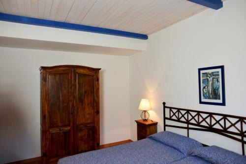 オルベテッロにあるAgriturismo Fattoria Il Casaloneのベッドルーム1室(ベッド1台付)、木製キャビネットが備わります。
