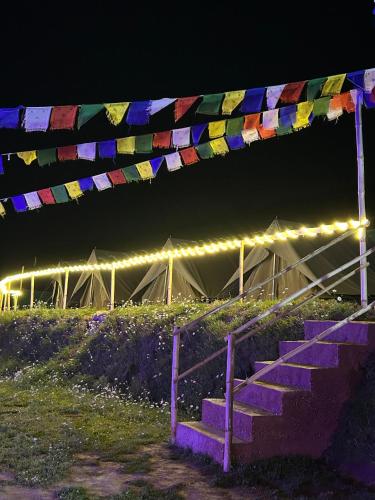 a bunch of flags hanging over a staircase at night at Shiya Camping By Eco Travellers in Lāhri