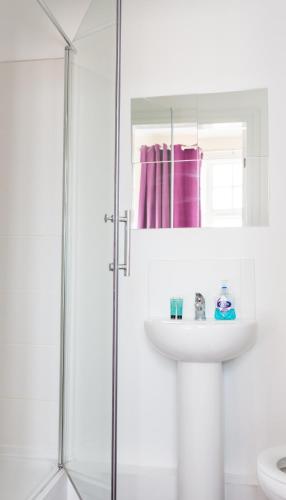 a white bathroom with a sink and a shower at The Star Inn in Nottingham