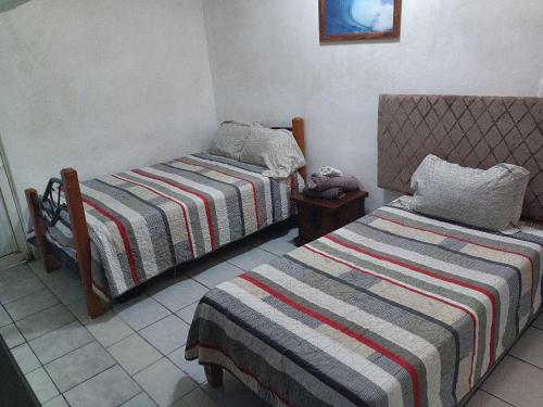 a room with two beds in a room at Barato y tranquilo olas in Manzanillo