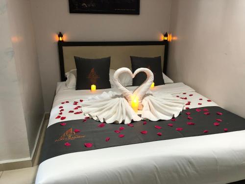 two swans made out of hearts sitting on a bed at DarulMakmur Scout Lodge in Kuantan