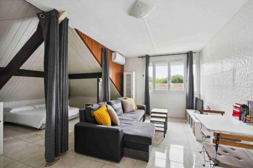 un salon avec un canapé et un lit dans l'établissement Le Charpenté, à Paray-Vieille-Poste