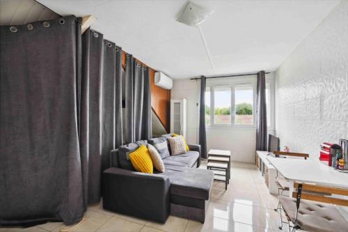 un salon avec un canapé et une table dans l'établissement Le Charpenté, à Paray-Vieille-Poste