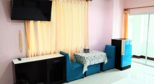 a room with a table and a chair and a tv at OYO 75399 Choktipparat Place in Udon Thani