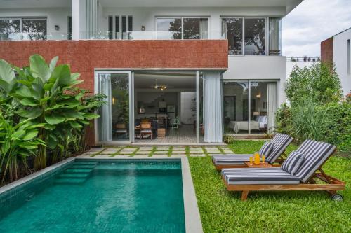 a backyard with a swimming pool and a house at La Dora -3BHK Contemporary Villas with Pvt Pool, 5 mins Walk to Vagator beach-Caretaker & Garden in Vagator