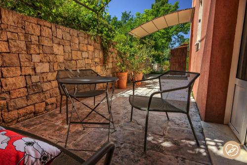 a patio with two chairs and a table at Hotel Les Restanques De Moustiers in Moustiers-Sainte-Marie