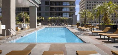 Una piscina con tumbonas y un edificio. en Penthouse High-Rise Ocean & City Views, en San Diego