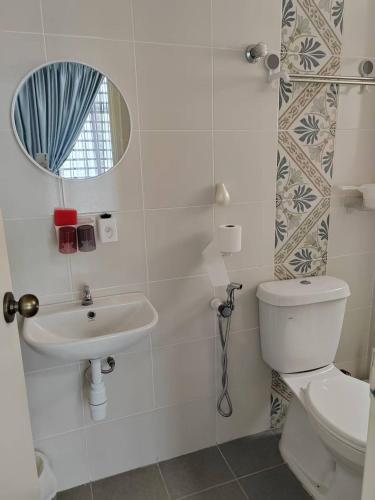 a bathroom with a toilet and a sink and a mirror at The Anderson by Triple G Homes in Ipoh