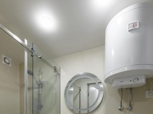 un baño con ducha y espejo en Вавілова апартаменти резиденція університету, en Chernivtsi