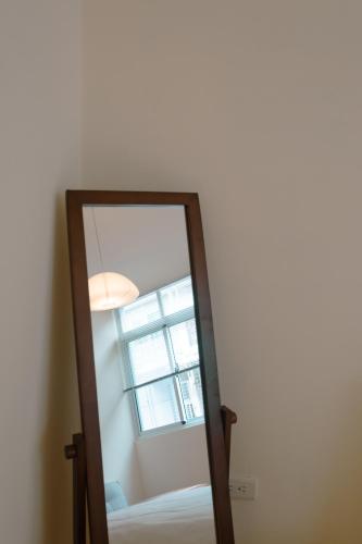 a mirror in a room with a window at Bou house in Tainan